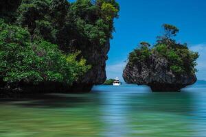 Aerial panorama of Thailand's verdant, lush tropical island, National Park Island, with blue and aquamarine the sea, and clouds shining by sunlight in the background. photo