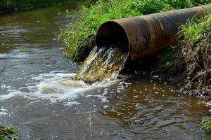 ai generado agua contaminación, ambiente contaminación. contaminado agua, sucio aguas residuales fluye desde tubo foto