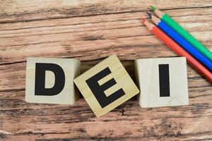 Concept of The wooden Cubes with the word DEI - Diversity Equity Inclusion on wooden background. photo