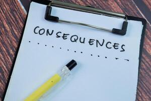 Concept of Consequences write on paperwork isolated on wooden background. photo