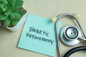 Concept of Diabetic Retinopathy write on sticky notes with stethoscope isolated on Wooden Table. photo