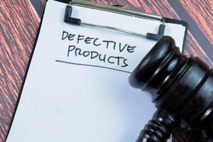 Concept of Defective Product write on paperwork with gavel isolated on wooden background. photo