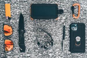 Flat lay of some Outdoor EDC gear on a grey background. photo