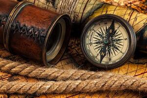 Old vintage compass and navigation instruments on ancient map photo