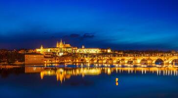 ver de Charles puente karluv más y Praga castillo prazsky hrad en crepúsculo. panorama foto