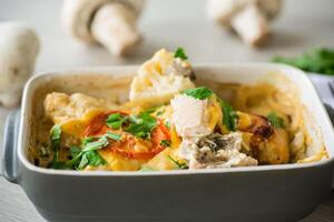 cauliflower baked with chicken fillet and mushrooms under cheese in a ceramic form photo