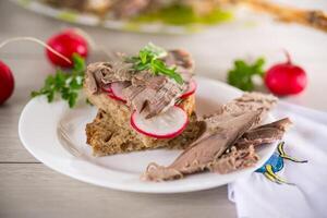 sandwich with baked meat, radish and herbs photo