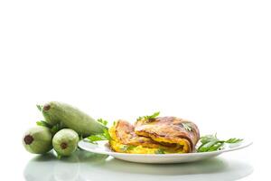 Fried omelette with zucchini,in a plate on a white background. photo