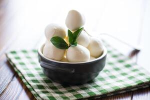 Small balls of traditional mozzarella in a ceramic bowl photo