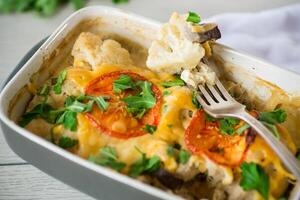 cauliflower baked with chicken fillet and mushrooms under cheese in a ceramic form photo