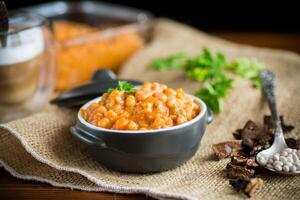 beans stewed with vegetables and spices, in a bowl . photo