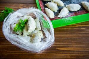 Raw green dough dumplings with parsley, dill. photo