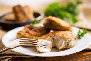 A piece of hake fish fried in a crispy crust, in a plate. photo