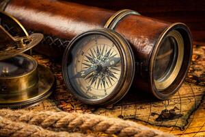 Old vintage compass and navigation instruments on ancient map photo