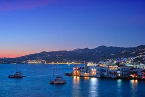 Sunset in Mykonos, Greece, with cruise ship and yachts in the harbor photo