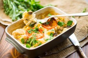 cauliflower baked with chicken fillet and mushrooms under cheese in a ceramic form photo