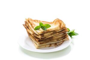 lot of pancakes thin pancakes in a plate, on white background. photo