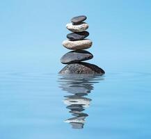 Zen balanced stones stack in lake balance peace silence concept photo