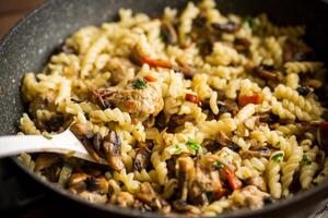 vermicelli cooked with mushrooms, meat and vegetables in a frying pan photo