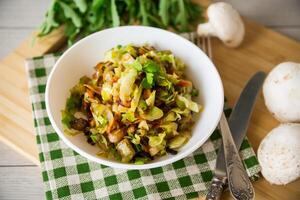 repollo temprano frito con hongos, zanahorias y vegetales foto