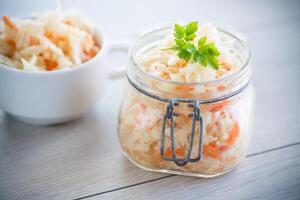 Sauerkraut with carrots and spices in a glass jar photo