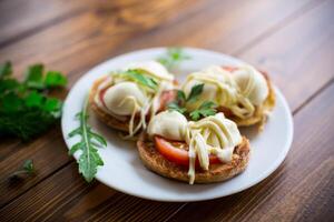 frito en masa emparedados con Tomates y queso Mozzarella en un plato con hierbas foto