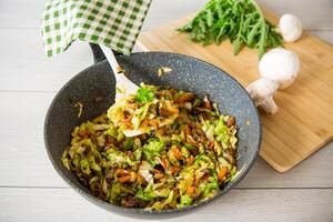 repollo temprano frito con hongos, zanahorias y vegetales foto