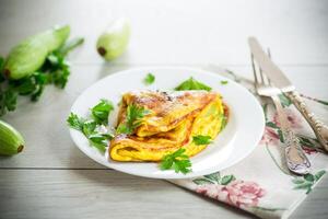 frito tortilla con calabacín, en un de madera mesa. foto