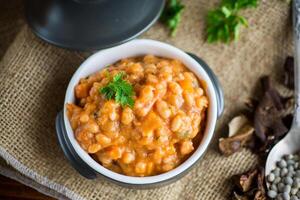 beans stewed with vegetables and spices, in a bowl . photo