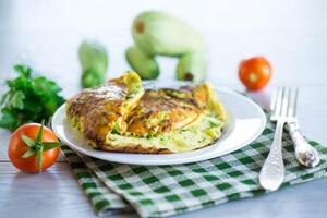 Fried omelet with zucchini, on a wooden table. photo