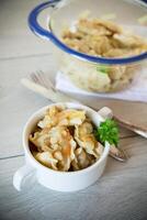 cooked dumplings with potatoes and fried onions on a wooden table. photo