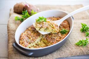 potato casserole with cabbage and spices in a ceramic form photo