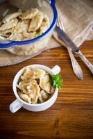 cooked dumplings with potatoes and fried onions on a wooden table. photo