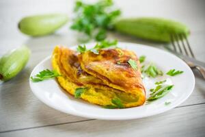 Fried omelet with zucchini, on a wooden table. photo