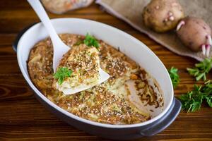 potato casserole with cabbage and spices in a ceramic form photo