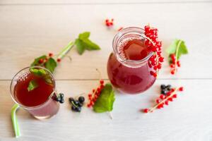 fresh berry juice from red and black currant, on a wooden table photo