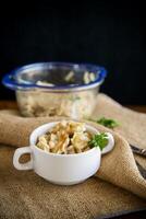 cooked dumplings with potatoes and fried onions on a wooden table. photo