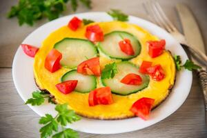 frito tortilla con calabacín, Tomates, hierbas en un plato foto