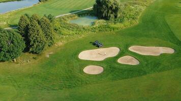 aérien vue de le le golf cours. une homme en jouant le golf sur une ensoleillé été journée. aérien vue de le vert le golf cours. frappe le Balle avec une le golf club. un actif type de des loisirs video