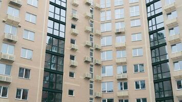 Front view of a recently built modern multi-story residential building. Exterior of a newly built modern residential building with baskets for air conditioners on the facade. video