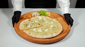 Homemade pizza with different types of cheese close-up on the table. video