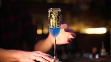 fabbricazione un alcolizzato cocktail. il barista versa un' cocktail. blu cocktail nel un' bicchiere. video