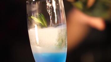 Making an alcoholic cocktail. The bartender pours a cocktail. Blue Cocktail in a glass. video