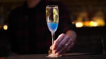 fabbricazione un alcolizzato cocktail. il barista versa un' cocktail. blu cocktail nel un' bicchiere. video