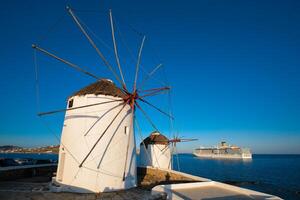 molinos de viento griegos tradicionales en la isla de mykonos al amanecer, cícladas, grecia foto