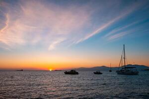 Sunset in Mykonos, Greece and yachts in the harbor photo