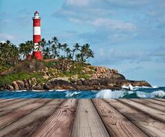 Wood planks floor with old lighthouse and waves of sea photo