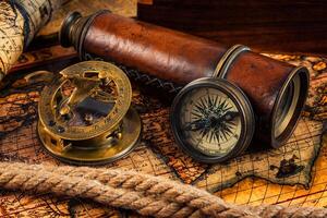 Old vintage compass and navigation instruments on ancient map photo