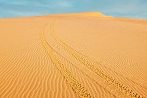todas terreno vehículo Canal de televisión británico pistas en blanco arena dunas en amanecer, foto