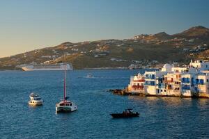 Sunset in Mykonos, Greece, with cruise ship and yachts in the harbor photo